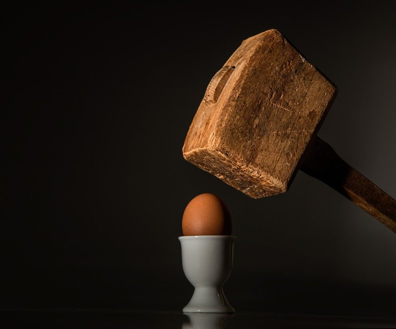 Boiled egg with large hammer symbolising the Tower moments that demolished my life during my spiritual awakening